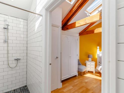 uma casa de banho com um chuveiro e uma parede de azulejos brancos em 1 Bed in Marazion 86149 em Saint Hilary