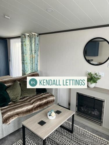 a living room with a couch and a fireplace at Sea View Lodge in Selsey