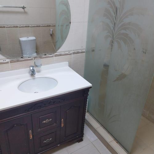 W łazience znajduje się umywalka i prysznic. w obiekcie العين الهيلي مصباح بيت14 w mieście Al-Ajn