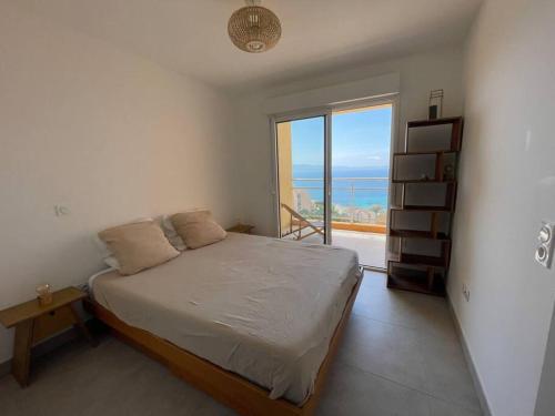 une chambre avec un lit et une grande fenêtre dans l'établissement Appartement T3 face à la mer, à Ajaccio