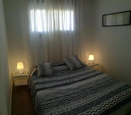 1 dormitorio con 1 cama grande y 2 lámparas en Apartamento PB 30min Sagrada Familia, 10 min playa en Badalona