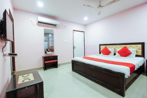 a bedroom with a large bed with red pillows at OYO Flagship Hotel Diamond Park in Kondapur