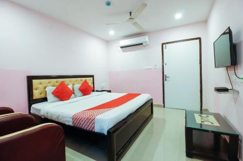 a bedroom with a bed and a tv and a couch at OYO Flagship Hotel Diamond Park in Kondapur