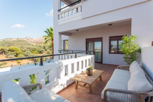 a balcony of a house with couches and a table at Sounds Of The Mountain Chania in Varípetron