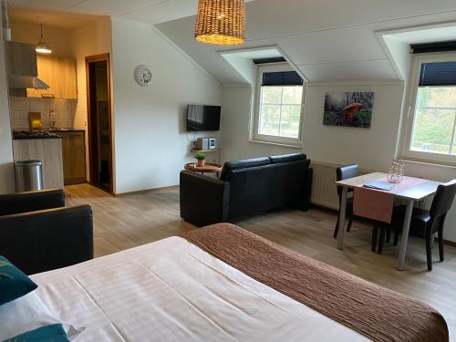 HeijenrathにあるAppartementen De Zegelskoëlのベッドとテーブルとキッチンのある寝室