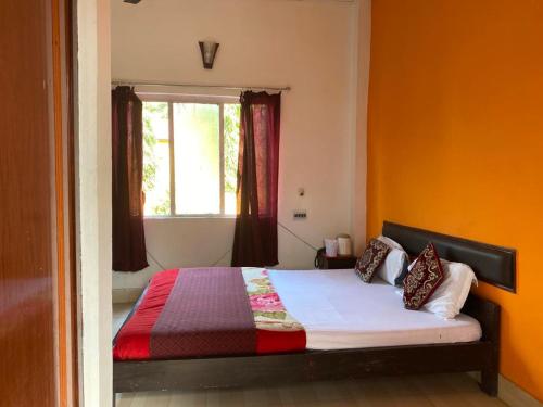 a bedroom with a bed and a window at THE MYSTIC FOREST-A TEA GARDEN RESORT in Mādāri Hāt