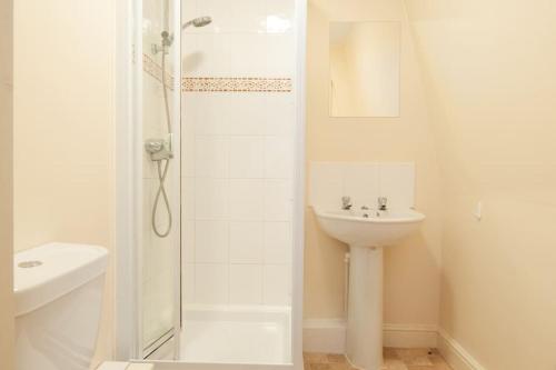 a white bathroom with a sink and a shower at *New* 2-Bed Modern Apartment in Burton upon Trent