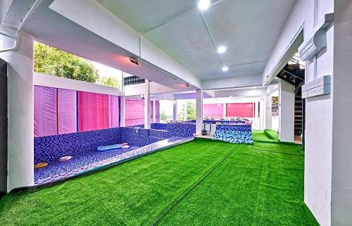 a room with blue chairs and green carpet at Penang Dream Banglo Sleeps 50 in Tanjung Bungah