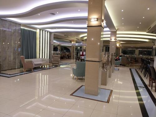 a lobby with chairs and tables in a building at Lydia Maris Resort & Spa in Kolymbia