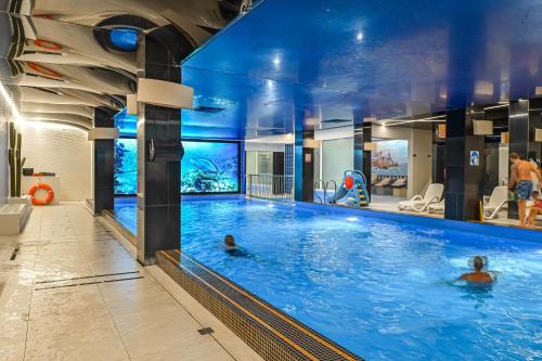 een zwembad in een hotel met twee personen in het water bij Hotel SPA Faltom Gdynia Rumia in Rumia