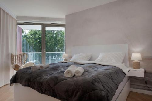 a white bedroom with a large bed with white pillows at Apartament Premium PINEA 107 in Pobierowo