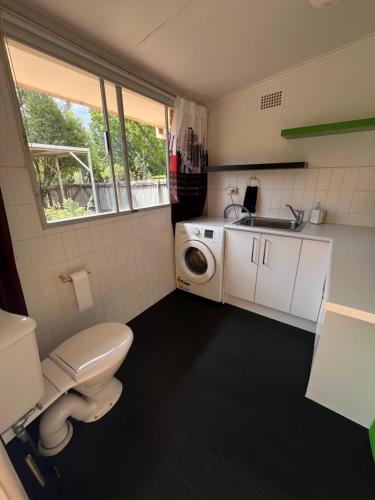 a small bathroom with a toilet and a sink at Perfectly located house with a big backyard. in Castle Hill