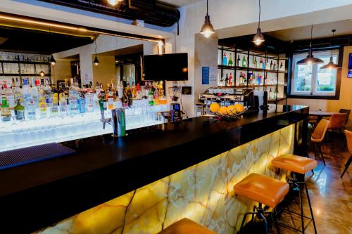 a bar with a counter with a lot of drinks at Nobel Gallery Hotel in Belgrade