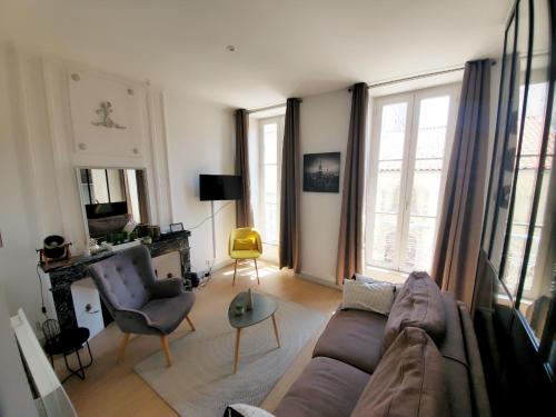 een woonkamer met een bank en 2 stoelen bij L'ORATOIRE 2 in La Rochelle