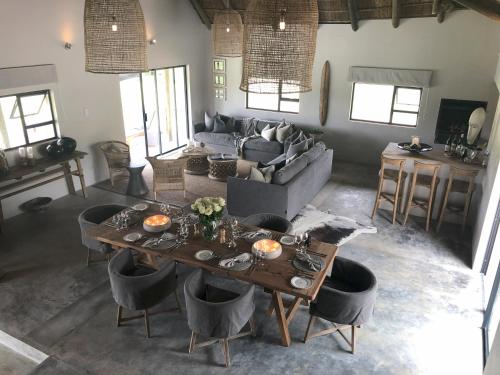 a living room with a table and a couch at Barefoot Addo Elephant Lodge - Luxury Family Villa in Addo
