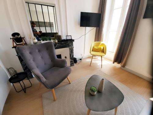 un salon avec une chaise et une table dans l'établissement L'ORATOIRE 2, à La Rochelle