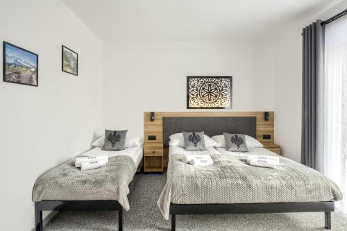 1 dormitorio con 2 camas y una foto en la pared en Willa Lasak, en Biały Dunajec