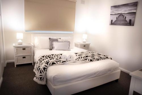 a bedroom with two beds and two night stands at Adina Lodge Holiday Apartments in Bright
