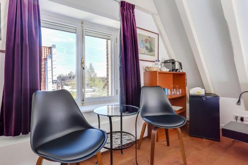 2 sillas y una mesa en una habitación con ventana en City-centre, Canal-house, luxurious , stylish bedroom, ensuite bathroom, own entrance, en Ámsterdam