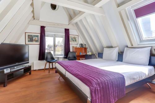 a bedroom with a bed and a flat screen tv at City-centre, Canal-house, luxurious , stylish bedroom, ensuite bathroom in Amsterdam