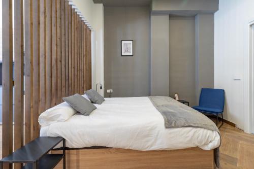 a bedroom with a large bed and a blue chair at Apartamento Acogedor céntrico MJ in Valencia
