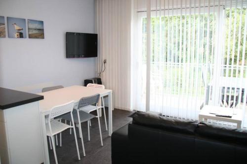 sala de estar con mesa blanca y sillas en Schorrebloem 21*, en Nieuwvliet