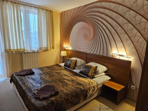 una camera da letto con un grande letto con una grande testiera di Enjoy Studio and Lovely Apartment Villa Park a Borovets