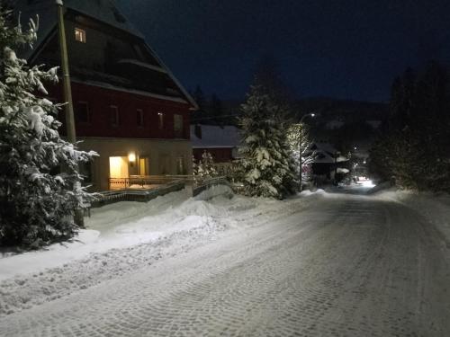 a snow covered street in front of a house at Apartament Alias in Wisła