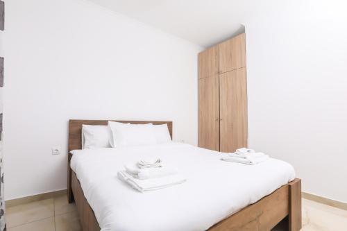 a bedroom with a white bed with a wooden headboard at Contessa Caterina in Karousádes