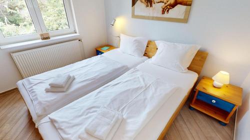 グレーミッツにあるGrüntal-Residenz Haus III App. 4のベッドルーム1室(大型ベッド1台、白いシーツ、枕付)