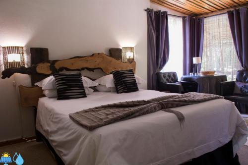 um quarto com uma cama grande e uma cabeceira em madeira em Riverbush Lodge Guesthouse em Parys