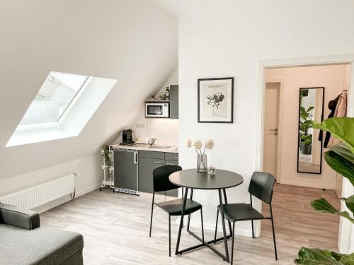 a kitchen and dining room with a table and chairs at Modernes Apartment in Diepholz in Diepholz