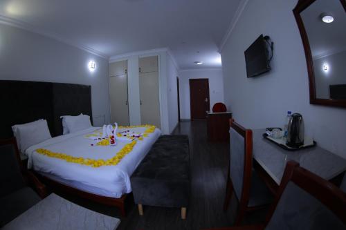 a bedroom with a large bed with a yellow blanket at Trinity Hotel in Addis Ababa