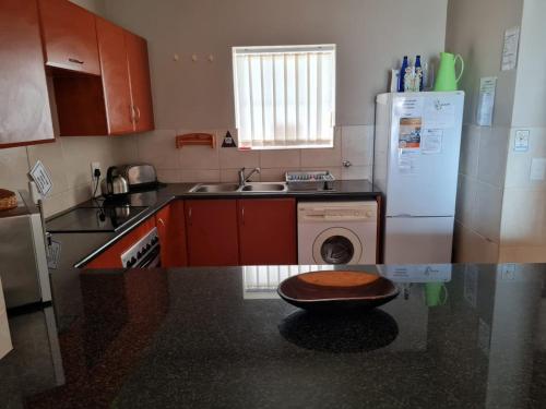 a kitchen with a washer and dryer on a counter at Point Village Accommodation - Estoril 26 in Mossel Bay