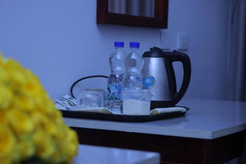 una encimera con botellas y vasos y un hervidor de agua. en Trinity Hotel, en Addis Ababa