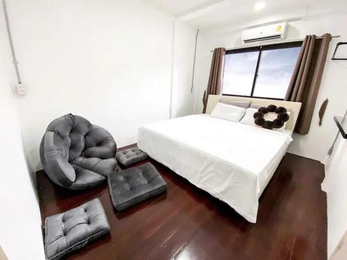 1 Schlafzimmer mit einem weißen Bett und 2 Stühlen in der Unterkunft 3BR entire house next to Skytrain(BTS) and Subway(MRT) Chatuchak in Bang O