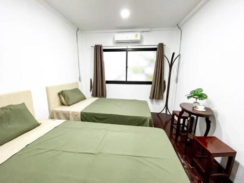 Cette petite chambre comprend 2 lits et une fenêtre. dans l'établissement 3BR entire house next to Skytrain(BTS) and Subway(MRT) Chatuchak, à Bang O