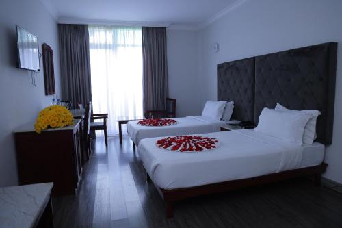 a hotel room with two beds and a table at Trinity Hotel in Addis Ababa