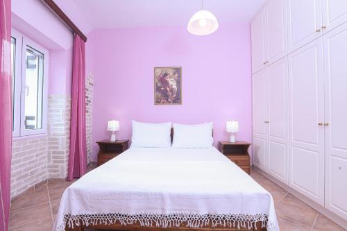 sypialnia z białym łóżkiem i 2 szafkami nocnymi w obiekcie Coryfo Casetta, Mon Repo w Korfu