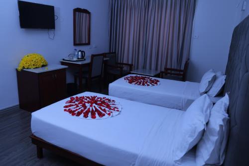 a hotel room with two beds and a desk at Trinity Hotel in Addis Ababa