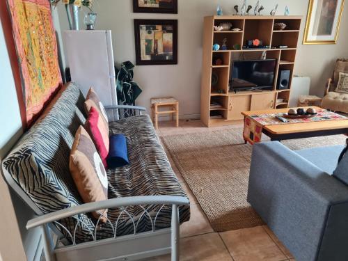 uma sala de estar com um sofá e uma mesa em Point Village Accommodation - Estoril 26 em Mossel Bay