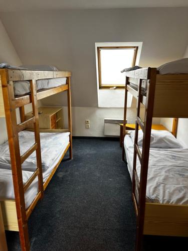 a room with two bunk beds and a window at Hotel Figura in Malá Morávka