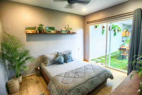 a bedroom with a bed and a large window at Beautiful Modern Garden Home in Kampot