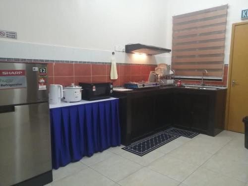 kuchnia z niebieskim stołem w kuchni w obiekcie Number Ten Guest House w mieście Ayer Keroh