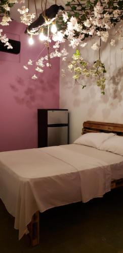 a bedroom with a bed with flowers on the wall at Tus Recuerdos in Santo Domingo