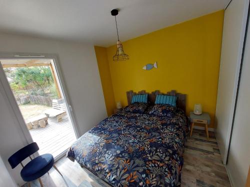 ein Schlafzimmer mit einem Bett in einem Zimmer mit einem Fenster in der Unterkunft VILLA HÉLIOS in Jard-sur-Mer