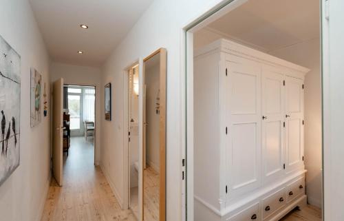 a hallway with white cabinets and a mirror at Heike in Westerland (Sylt)