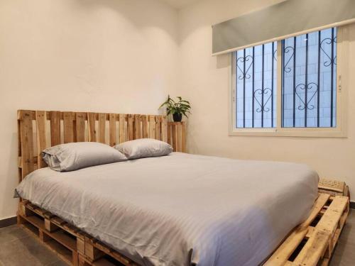 um quarto com uma cama de madeira e uma janela em Charming 2BR Gemayze em Beirute