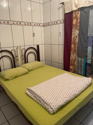 2 camas en una habitación con sábanas verdes en Casa Família Mattos en Xangri-lá