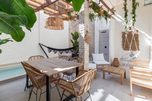 Un patio con mesa y sillas y una hamaca. en Apartamento con piscina y terraza, en Valencia